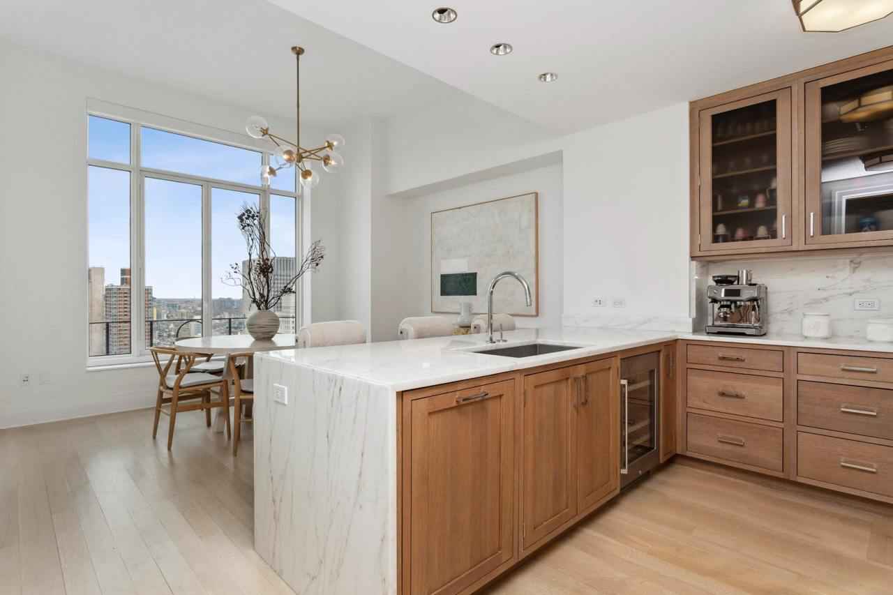 a kitchen with a marble island and wooden cabinets