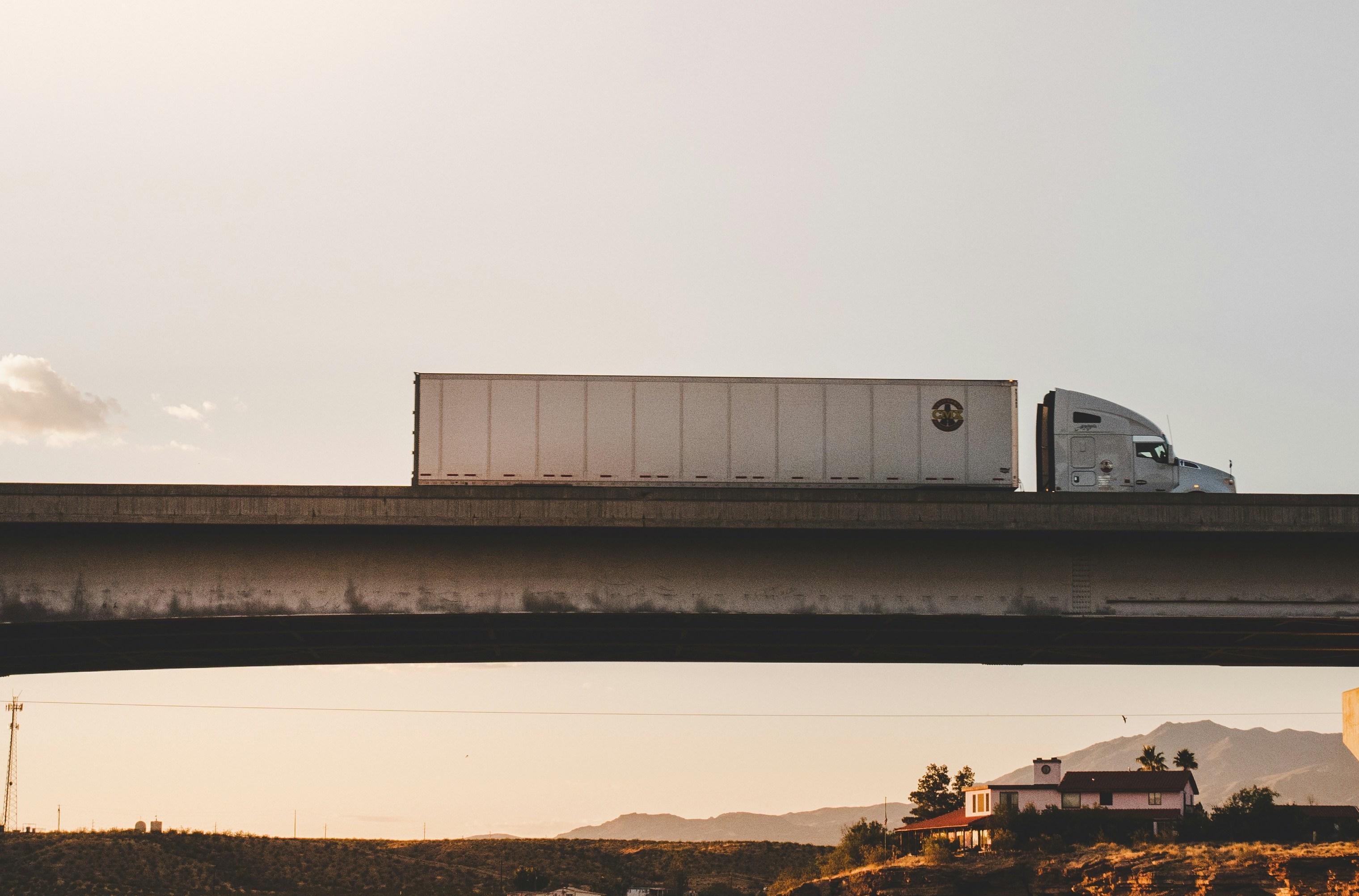 a truck is driving on a bridge over a river