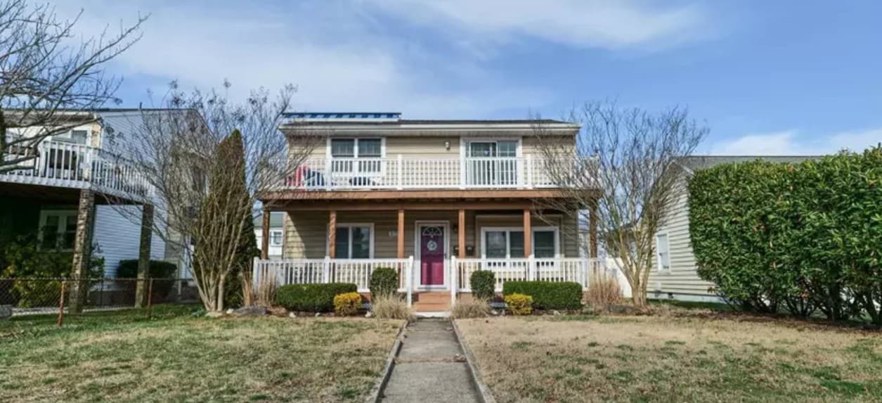 a two story house with a front yard and a small yard