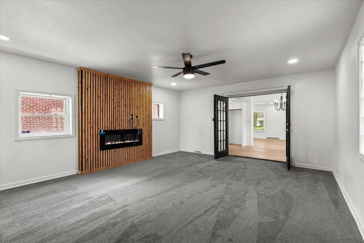 a living room with a large window and a large wooden floor