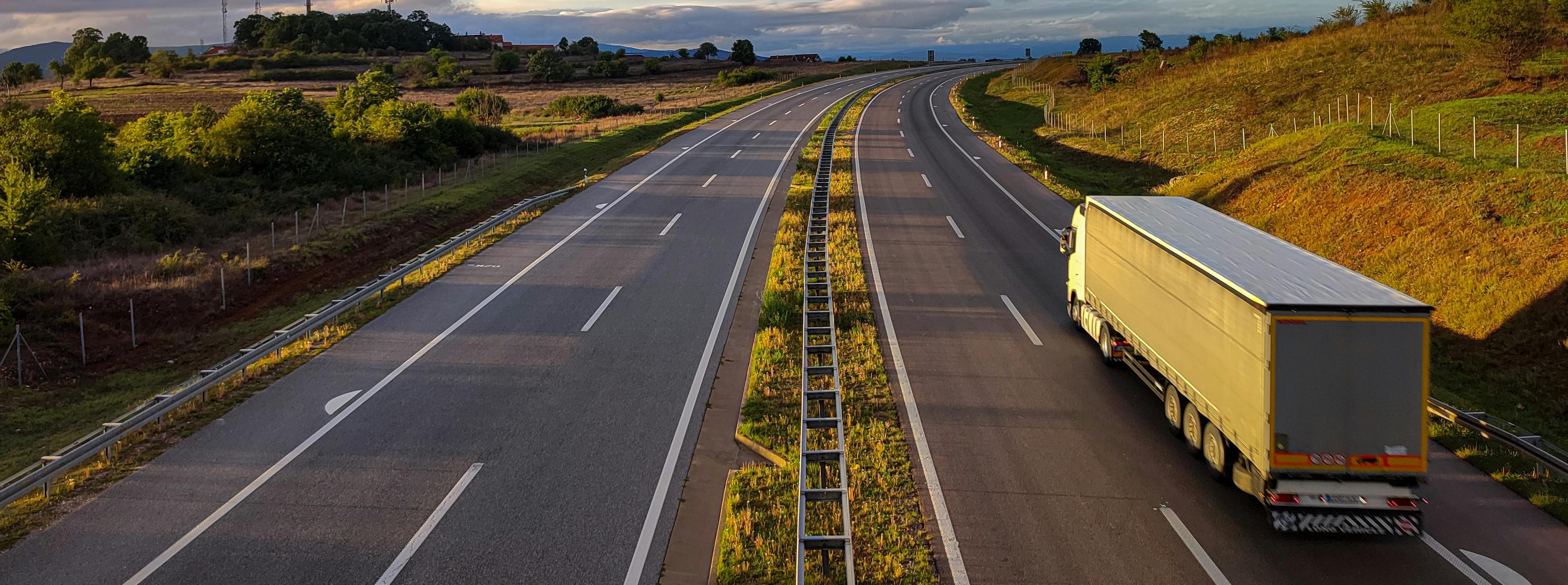 Long-haul moving truck driving on a highway, representing the scale and logistics of the U.S. moving industry.